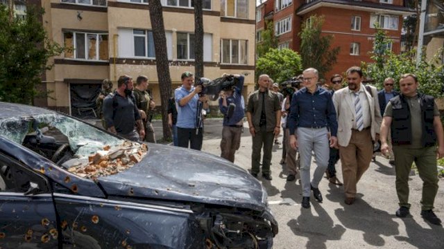 PM Australia Anthony Albanese (ketiga dari kanan, depan) melihat kendaraan dan bangunan apartemen yang hancur akibat gempuran Rusia dalam kunjungan ke Irpin, pinggiran Kyiv, Ukraina, Minggu (3/7/2022). Foto: ist