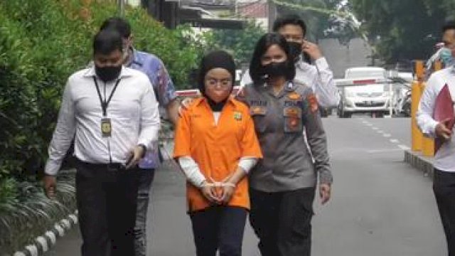 Medina Zein kenakan baju tahanan dan tangan diborgol. Foto: KH Infoteinment
