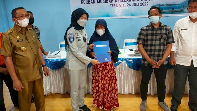 Direktur Operasional Jasa Raharja Dewi Aryani Suzana menyerahkan santunan kecelakaan KM Cahaya Arafah, Selasa (26/7/2022). Foto: dok