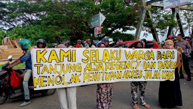  Warga membentangkan spanduk sebagai wujud penolakan rekayasa lalu lintas di kawasan Jembatan Barombong, Selasa (9/8/2022). Foto: dok