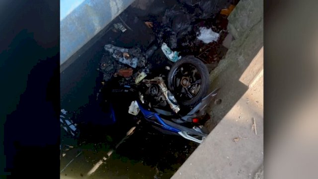  Satu unit motor matic warna biru yang berada di bawah kanal (ist)