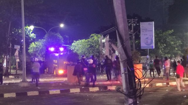 Saling serang antara massa aksi dengan personel Brimob di Jl AP Pettarani, Senin (5/9/2022) malam. Foto: PORTALMEDIA/Al Fath 