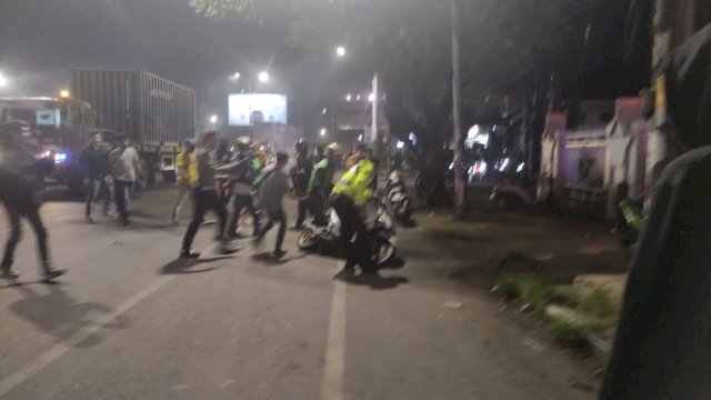 Suasana kericuhan massa aksi dengan warga sekitar, di depan kampus UNM, Senin (5/9/2022) malam. Foto: PORTALMEDIA/Al Fath