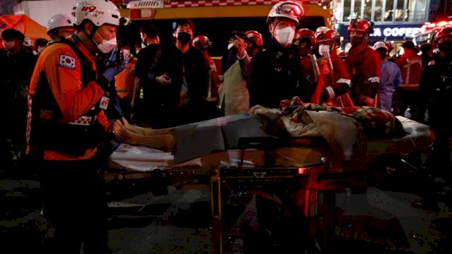 Tim penyelamat memindahkan korban dengan tandu di distrik Itaewon Seoul setelah terinjak-injak saat pesta Halloween di Seoul. Foto: ist