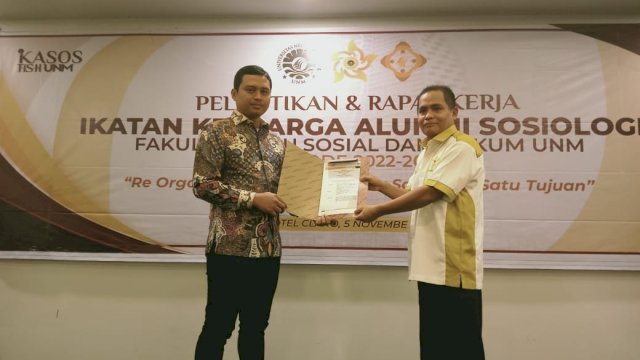 Ketua Komisariat IKA FIS-H UNM, Dr. Najamuddin, M. Hum saat menyerahkan SK pengurus Ikasos FIS-H UNM yang diterima langsung Ketua Fachruddin S Bintang (Portal Media/Reza) 