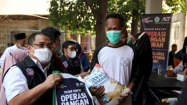 Presiden ACT Ibnu Khajar (kiri) saat memberikan paket sembako dalam Operasi Pangan Murah ACT . Foto: dok ACT