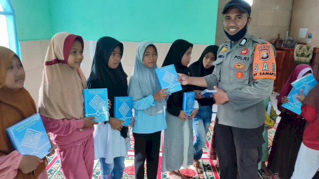 Brigpol Suryadi S yang membagikan sejumlah Alquran baru kepad beberapa anak-anak di salah satu desa pelosok Kabupaten Takalar. Foto: ist