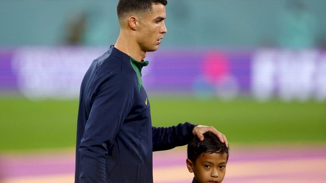 Pemain Portugal Cristiano Ronaldo dengan pendamping pemain sebelum pertandingan melawan Ghana di Stadion 974, Doha, Qatar, Kamis (24/11/2022). Foto: Hannah McKay/REUTERS