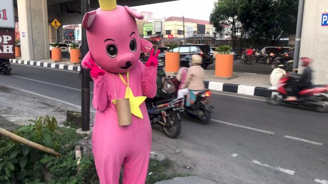 Salah satu badut aksi di sudut kota Makassar. (portalmedia)