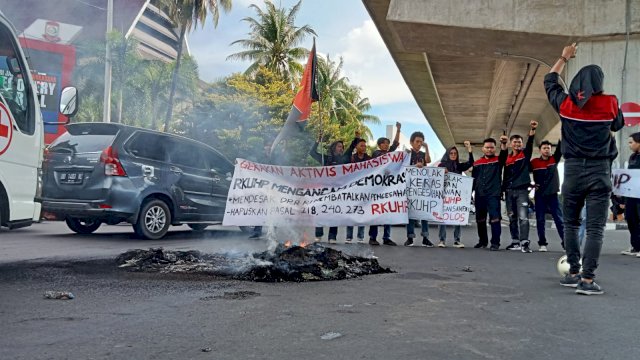 Aksi demonstrasi di ruas jalan AP Pettarani Kota Makassar, mahasiswa menuntut sejumlah pasal dihapus dalam RKUHP yang akan disahkan oleh DPR RI. Foto: Portalmedia.id/Reza