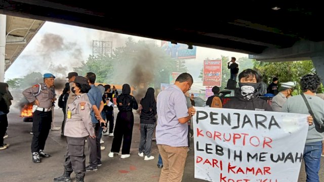 Salah seorang massa aksi yang tergabung dalam Aliansi Garda Tipikor membentangkan spanduk kritikan penanganan korupsi(Portal Media/Reza)