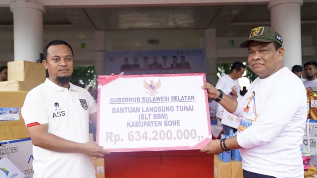 Gubernur Sulsel, Andi Sudirman Sulaiman saat menyerahkan bantuan kepada Bupati Bone, A. Fashar M. Padjalangi pada acara  jalan santai Sulsel Anti Mager di Lapangan Merdeka Watampone, Minggu (18/12/2022)/IST