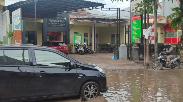 Kondisi jalan di depan Puskesmas Samata yang tergenang air, akses warga yang ingin berobat jadi terhambat (Portal Media/Irham)