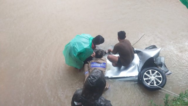 Proses evakuasi para korban yang terjebak dalam mobil usai menabrak pohon dan terjun ke sungai (ist)