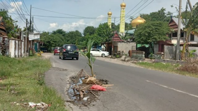 Salah satu jalan rusak berlubang di poros Jeneponto terpaksa ditutupi pohon dan sampah guna menghindari kecelakaan. (Foto: Akbar Razak/Portalmedia) 