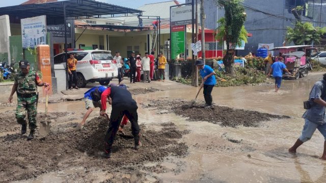  Penimbunan Jalan Provinsi di depan Puskesmas Samata dilakukan anggota DPRD Gowa, Tripika Somba Opu beserta warga setempat. (Foto: Irham/Portalmedia.id)