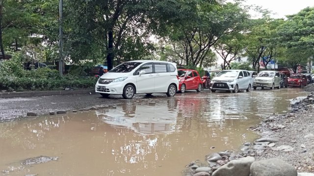 Sejumlah kendaraan roda dua dan roda empat melintasi jalan berlubang di Jalan Aroepala, Makassar (Portal Media/Reza)