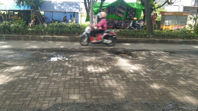 Ruas Jalan Hertasning-Aroepala yang di tambal dengan paving blok. Foto: Portalmedia.id/Irham