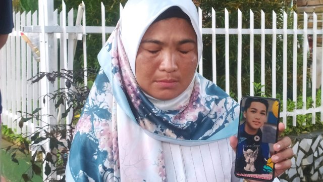 Ibu AA Rahmawati saat menunjukkan foto mendiang putranya. (Ist)
