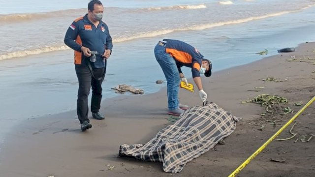 Tim Inafis Polrestabes Makassar yang melakukan pemeriksaan terhadap jasad pria tanpa identitas yang ditemukan terdampar dibibir pantai kawasan wisata Tanjung Bayang (ist/reza/portalmedia)