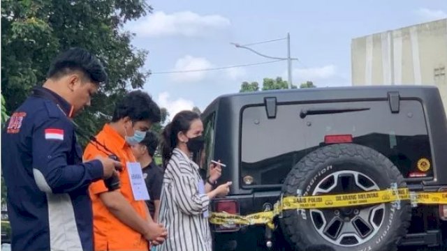 Agnes diperankan pemeran pengganti (kemeja garis-garis) merokok dalam rekonstruksi kasus penganiayaan David di kompleks Green Permata, Pesanggrahan, Jakarta Selatan, Jumat (10/3/2023). Foto: suara.com