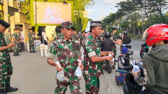 Beberapa personel dari Sansidam XIV Hasanuddin membagikan bingkisan takjil ke para pengendara (ist)