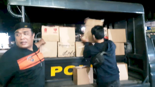 Polisi yang menyita beberapa kardus berisi ratusan botol miras saat razia jelang hari raya idul fitri (ist)