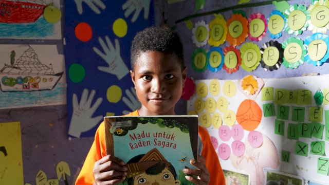 Seorang anak di desa Nermnu, Biak, Papua, bersama buku kesayangannya/Ist