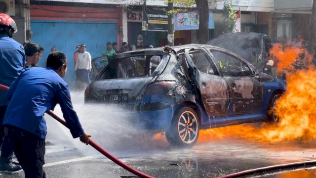 Proses pemadaman api saat sebuah mobil City Car merek Peugeot terbakar di Jalan Pengayoman Kota Makassar/st