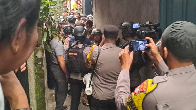 Pihak kepolisian saat berusaha mengevakuasi pelaku dari amukan massa/ist
