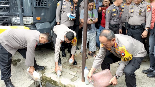 Pemusnahan minuman keras tradisional di kantor Samapta Polrestabes Makassar, Jalan Arif Rate, Kota Makassar, Minggu siang (24/12/2023).(Portal Media/Aldy) 