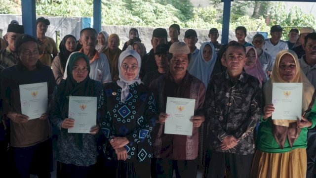 SERTIFIKAT. Bupati Kabupaten Luwu Utara, Indah Putri Indriani  menyerahkan sertifikat tanah melalui program redistribusi tanah kepada warga di Desa Bakka.