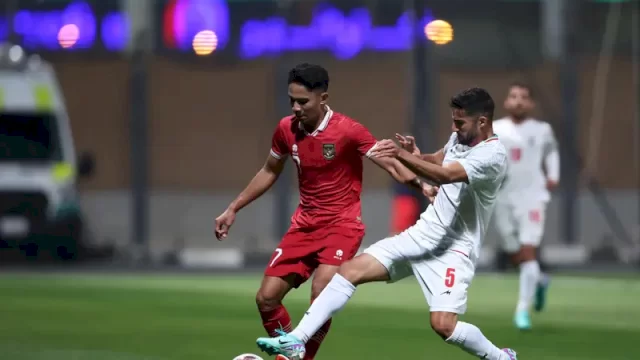 KALAH LAGI. Gelandang Timnas Indonesia, Marselino Ferdinan, berduel dengan bek Iran, Milad Mohammadi, dalam laga uji coba yang digelar di Al Rayyan Training Ground, Qatar, Selasa (09/01/2024) malam. Timnas Indonesia kalah 0-5 dalam laga ini.