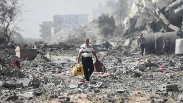Seorang warga mengangkat barangnya yang tersisa akibat konflik di Gaza, Palestina.