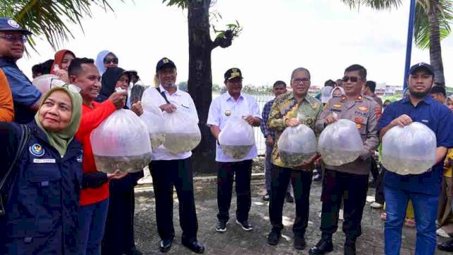 TEBAR BENIH. Wali Kota Makassar Mohammad Ramdhan Pomanto bersama Pj Gubernur Sulsel Bahtiar Baharuddin bersama-sama melakukan tebar benih ikan air tawar di Waduk Tunggu Pampang, Sabtu (06/04/2024).