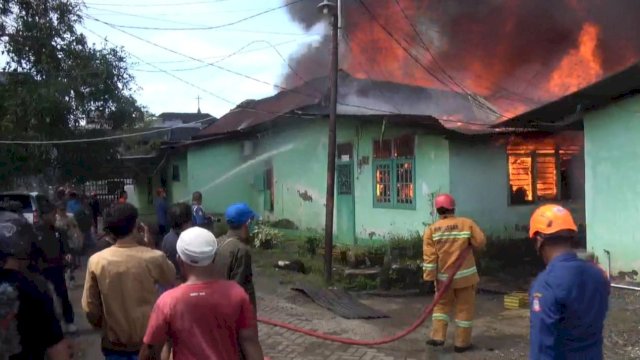 Petugas pemadam berusaha memadamkan kobaran api yang menghanguskan puluhan rumah di Kesdam XIV Hasanuddin, Sabtu kemarin.
