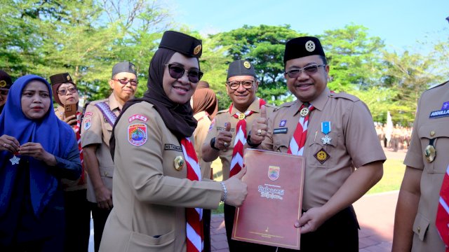 Bupati Gowa selaku Ketua Kwartir Cabang Pramuka Gowa, Sitti Husniah Talenrang memberikan penghargaan kepada Wakil Bupati Gowa, Darmawangsyah Muin  pada Upacara Peringatan Hari Ulang Tahun (HUT) Ke-64 Gerakan Pramuka yang dilaksanakan di Lapangan Upacara Kantor Bupati Gowa, Rabu (13/8/2025).
