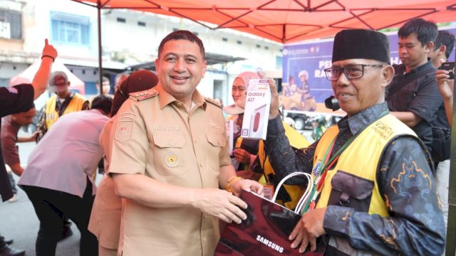 Wali Kota Makassar, Munafri Arifuddin menyerahkan enam unit smartphone kepada juru parkir (jukir) pengguna QRIS Perumda Parkir Makassar Raya.
