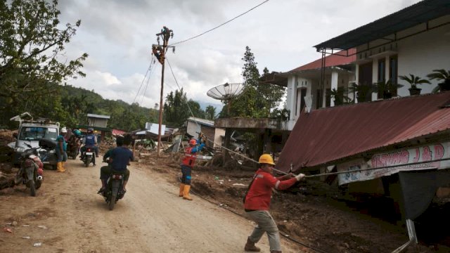 Petugas PLN melakukan penarikan kabel untuk disambungkan ke tiang-tiang listrik jaringan tegangan rendah (JTR) baru di Kabupaten Agam. 