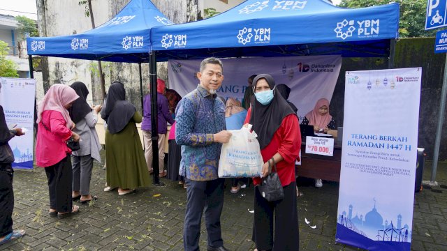 General Manager PLN UID Sulselrabar, Edyansyah (kiri) menyerahkan paket sembako murah kepada masyarakat dalam kegiatan Terang Berkah Ramadan 1447 H. Program ini merupakan wujud kepedulian PLN untuk membantu masyarakat memenuhi kebutuhan pokok di bulan suci Ramadan.