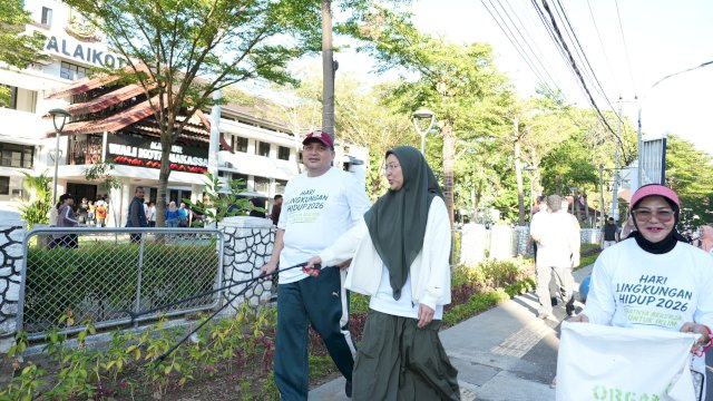 Wali Kota Makassar Munafri Arifuddin bersama Ketua TP PKK Melinda Aksa memegang alat penjepit sampah saat memimpin aksi jalan sehat plogging peringatan Hari Lingkungan Hidup Sedunia 2026 di Makassar, Sabtu (6/6/2026).