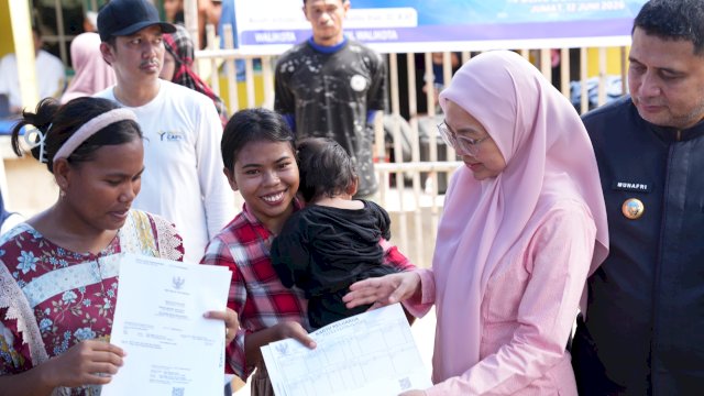 Ketua TP PKK Kota Makassar, Melinda Aksa (kanan), bersama Wali Kota Munafri Arifuddin (paling kanan) saat menyerahkan secara simbolis dokumen kependudukan hasil layanan jemput bola kepada warga di Pulau Bone Tambu, Kecamatan Kepulauan Sangkarrang, Jumat (12/6/2026). Layanan ini dihadirkan untuk mempermudah warga pulau mendapatkan KTP dan Akta tanpa harus ke daratan.