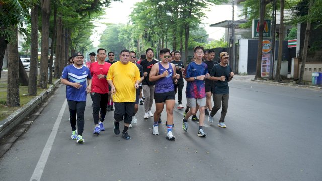 Wali Kota Makassar, Munafri Arifuddin (tengah, jersey kuning), saat memimpin gerakan lari pagi bersama puluhan runners menyusuri jalanan kota usai melepas peserta di halaman Balaikota Makassar, Ahad (5/4/2026), sebagai bagian dari kampanye hidup sehat sekaligus hitung mundur menuju Makassar Half Marathon (MHM) 2026.
