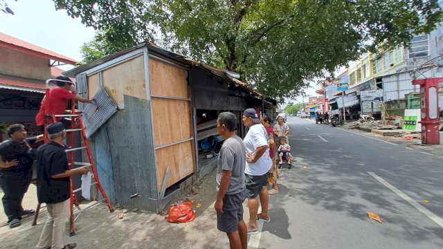 Tim gabungan dari Pemerintah Kecamatan Tallo dan kelurahan saat bahu-membahu membongkar material seng dan kayu dari tiga unit lapak liar yang telah menyumbat saluran drainase selama lima tahun di Jalan Datuk Patimang, Kelurahan Kalukuang, Minggu (5/4/2026).