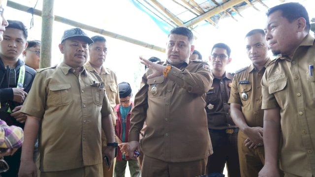 Kota Makassar, Munafri Arifuddin (tengah, seragam dinas cokelat), didampingi perwakilan Dinas Pertanahan, DBMBK Sulsel, serta Aparat Penegak Hukum (APH), saat berdiskusi dan meninjau langsung patok koordinat pembebasan lahan untuk proyek Jembatan Kembar Barombong, Selasa (7/4/2026).
