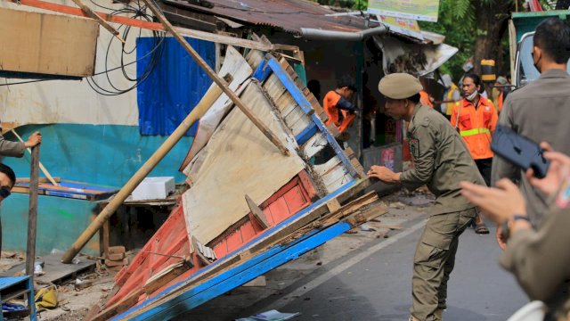 Personel Satuan Polisi Pamong Praja (Satpol PP) bersama petugas Kecamatan Makassar saat melakukan pembongkaran dan penataan lapak pedagang kaki lima (PKL) yang menyalahgunakan fungsi trotoar di Jalan Gunung Salahutu, Kelurahan Maradekaya Utara, Selasa (7/4/2026). Kegiatan berjalan tertib mengedepankan pendekatan dialogis dan humanis.
