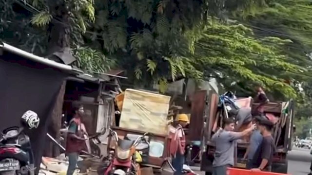 Suasana pembongkaran dan pembersihan sisa material lapak pedagang kaki lima (PKL) yang berdiri di atas fasilitas umum di wilayah Kecamatan Mariso, Makassar, Rabu (8/4/2026). Sejumlah warga bersama petugas bahu-membahu menaikkan papan kayu ke atas armada truk angkutan dalam suasana yang kondusif.