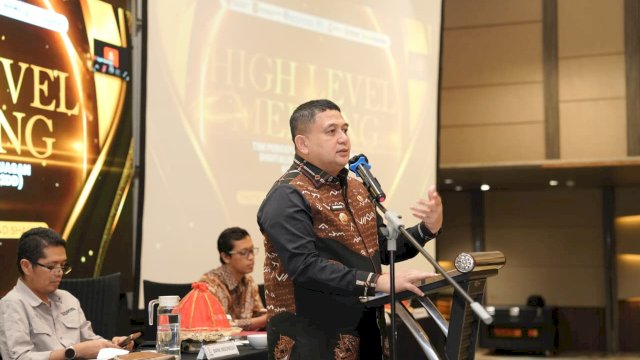 Wali Kota Makassar, Munafri Arifuddin (kanan, berdiri di podium), saat memberikan pengarahan tegas dalam pembukaan High Level Meeting Tim Percepatan dan Perluasan Digitalisasi Daerah (TP2DD) Kota Makassar Tahun Anggaran 2026 di Hotel Grand Novotel Shayla, Kamis (9/04/2026). Wali Kota menginstruksikan seluruh jajaran SKPD untuk menerapkan prinsip walk the talk dalam digitalisasi transaksi guna menggenjot PAD.