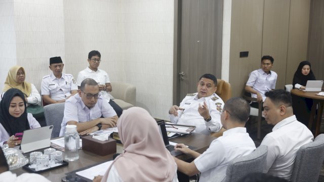 Wali Kota Makassar, Munafri Arifuddin (tengah, berbaju putih dengan tanda jabatan), didampingi Kepala Dinas Pertanahan Kota Makassar Sri Sulsilawati (kiri, jilbab hitam memegang gawai) saat memberikan instruksi tegas dalam rapat koordinasi penataan aset daerah di Kantor Balai Kota Makassar. Dalam rapat monitoring tersebut, Wali Kota memberikan deadline kepada seluruh camat dan kepala OPD terkait untuk bersinergi mengejar target sertifikasi 1.000 aset lahan pemerintah dan ribuan ruas jalan sepanj