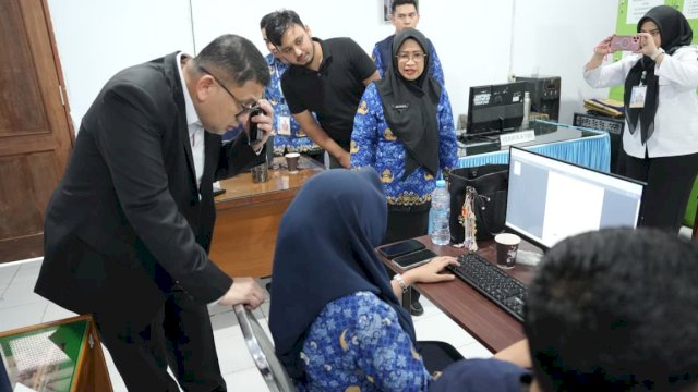 Wali Kota Makassar Munafri Arifuddin saat mengamati lembar dokumen digital pendaftaran calon peserta didik pada layar dasbor komputer guna memastikan akurasi data verifikasi SPMB 2026 di lingkungan sekolah.